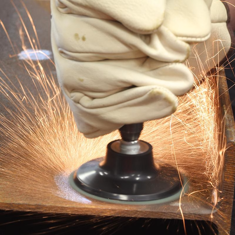 GRFC7560_2 - Alpha Tools Gloved hand operating a power grinder, grinding a metal surface with bright orange sparks flying around.